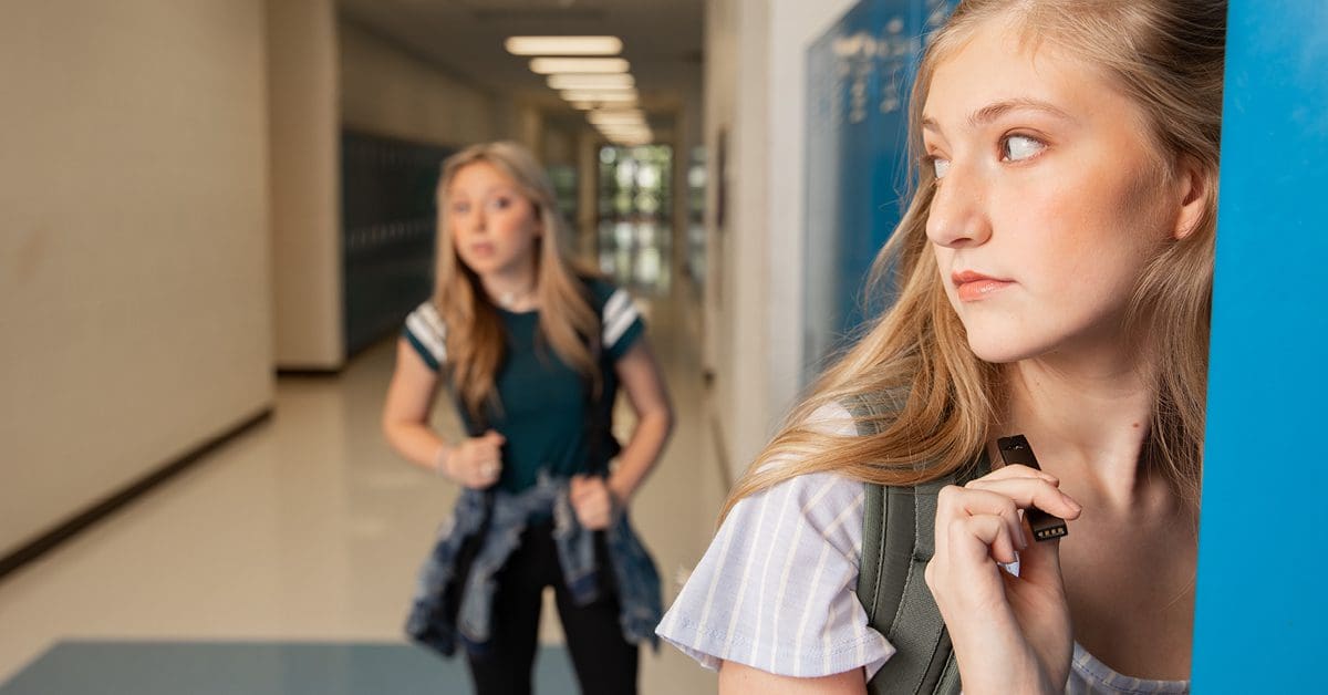 Two high school girls in hallway with lockers