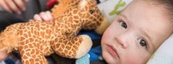 A baby holding a stuffed animal giraffe