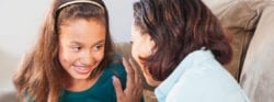 A woman talking to a child with braces