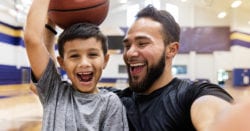 Dad and young son at indoor basketball court