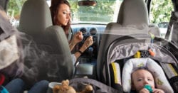 A mother smoking a cigaret with her baby in the car