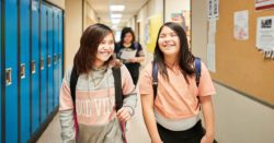 Two school girls laughing in the hallway