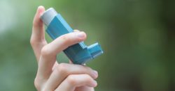 A person holding an inhaler