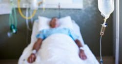 A man laying in a medical bed with medical devices hooked up to him.