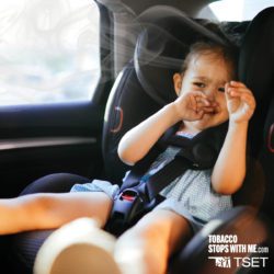 A child in a car seat inhaling secondhand smoke