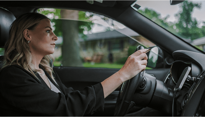 Woman smoking cigarette while driving with window cracked