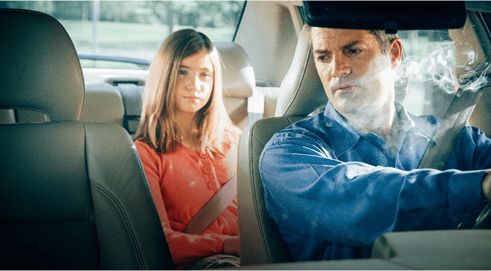 Father in car with smoke and daughter in the back sear