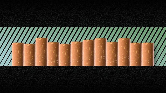 Cigarettes lined up on green striped background